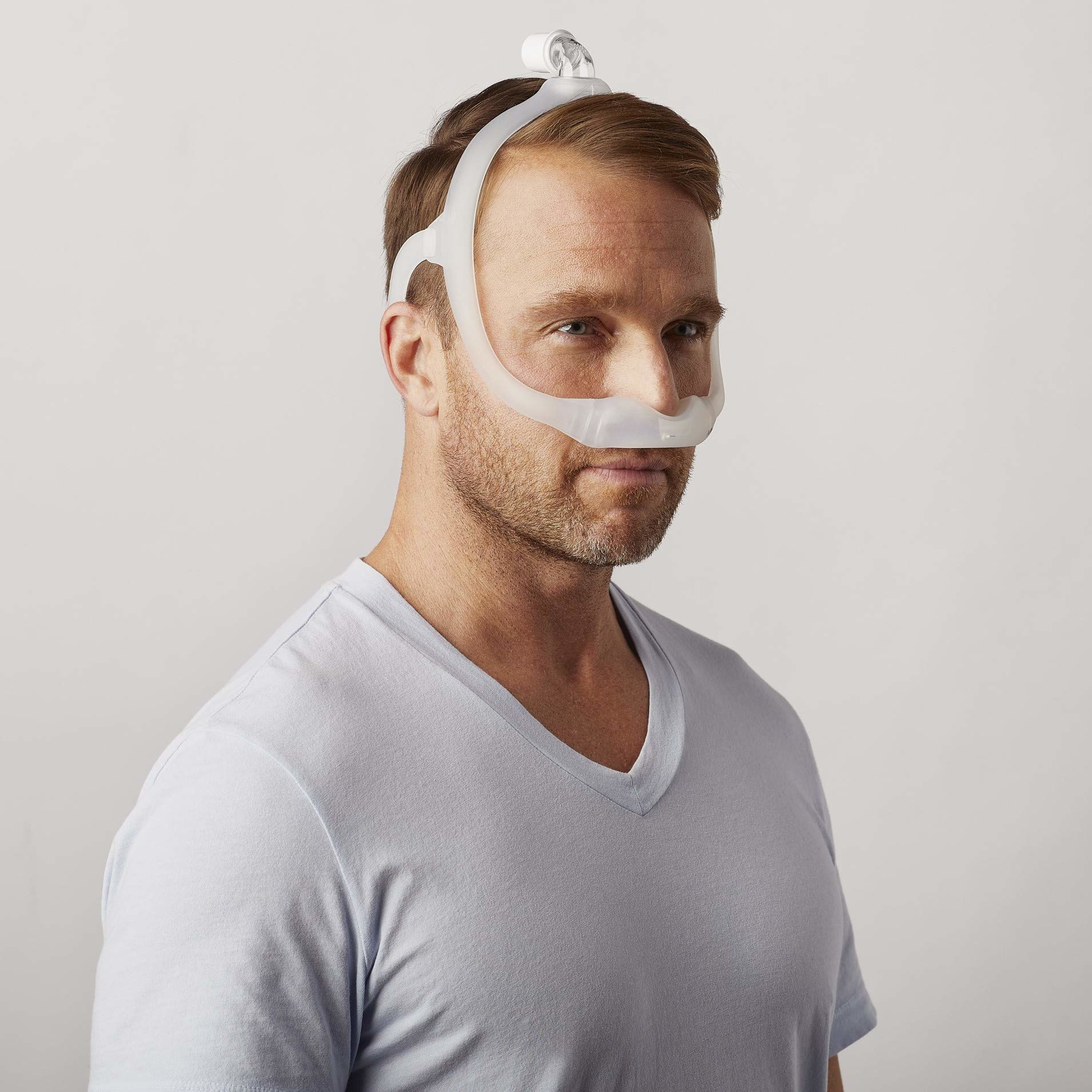 A man wearing the Philips Respironics DreamWear nasal mask that fits under the nose.