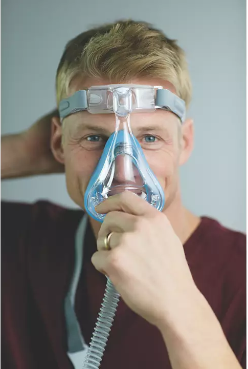 A man  using a Philips Respironics Amara Gel Full Face CPAP mask to breathe