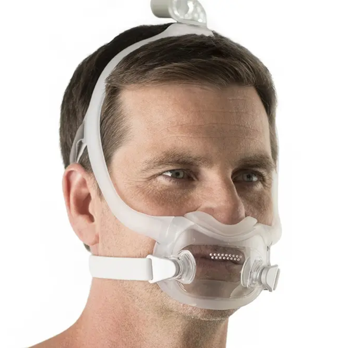 Close-up of a man wearing a Philips Respironics DreamWear Full Face CPAP mask with headgear, designed for comfortable sleep apnea therapy and a secure fit.